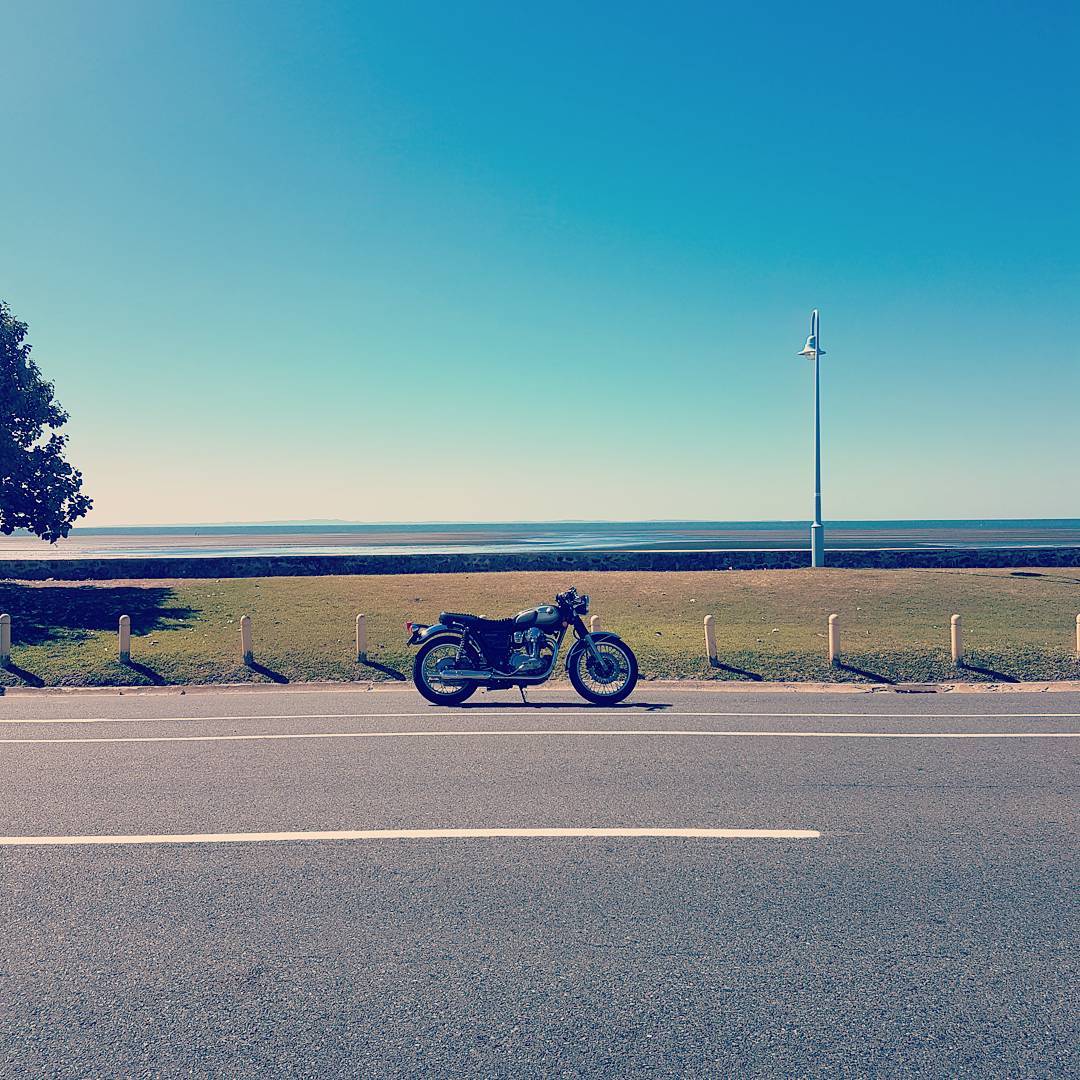 Kawasaki W800 classic style motorcycle near ocean